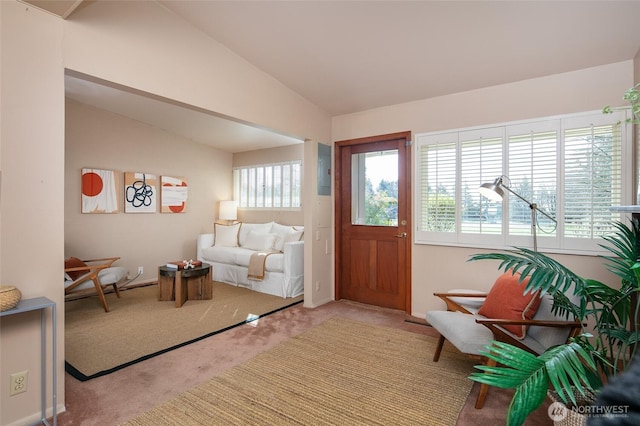 carpeted entryway with vaulted ceiling