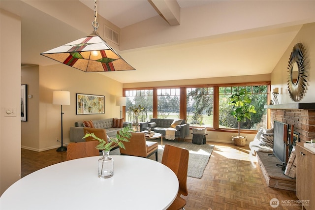 dining space featuring vaulted ceiling with beams, baseboards, visible vents, and a fireplace with raised hearth