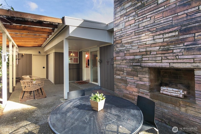 view of patio featuring outdoor dining area and an outdoor stone fireplace