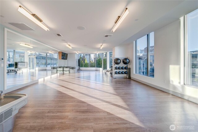 interior space featuring floor to ceiling windows, visible vents, and wood finished floors