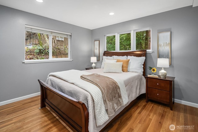 bedroom with baseboards, wood finished floors, and recessed lighting