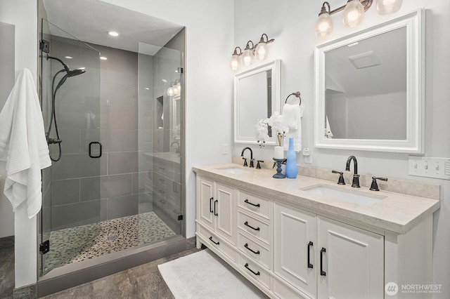 full bathroom featuring a sink, a shower stall, and double vanity