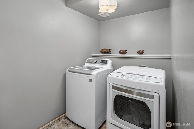 washroom featuring washer and dryer, laundry area, and visible vents