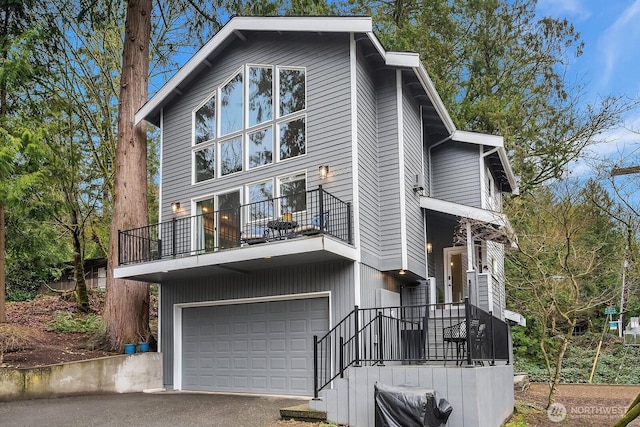 view of front of home with a balcony, a garage, and aphalt driveway