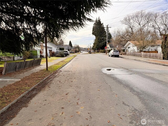 view of road featuring sidewalks, street lighting, a residential view, and curbs