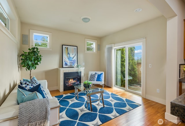 sitting room with wood finished floors, baseboards, and a tile fireplace