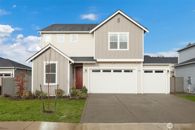 traditional home with board and batten siding, a front yard, driveway, and fence