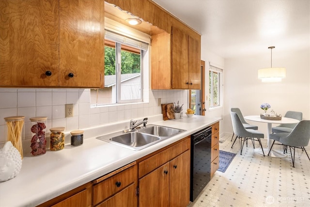 kitchen featuring a sink, light countertops, dishwasher, brown cabinetry, and pendant lighting