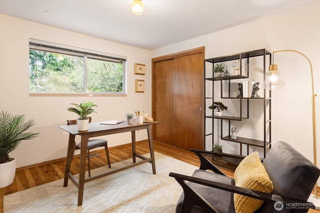 home office featuring baseboards and light wood finished floors