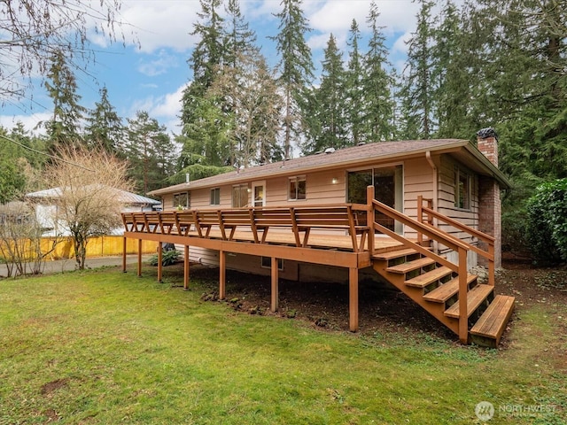 back of property featuring a deck, a yard, and a chimney