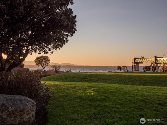 yard at dusk with a water and mountain view