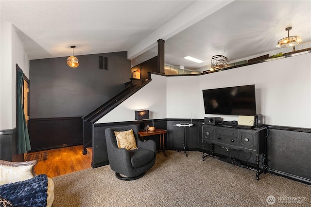 interior space featuring lofted ceiling with beams, carpet floors, visible vents, and wainscoting