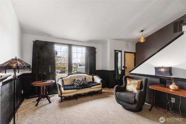 sitting room featuring a wainscoted wall, carpet floors, a textured ceiling, and visible vents