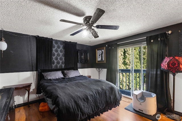 bedroom with a textured ceiling, a ceiling fan, and wood finished floors