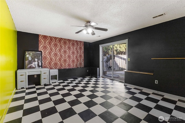 unfurnished living room with visible vents, ceiling fan, a textured ceiling, baseboards, and tile patterned floors