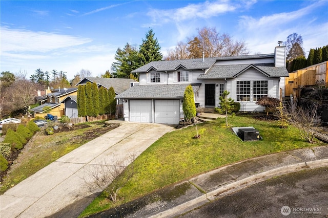 view of front of property featuring a front yard, concrete driveway, fence, and an attached garage