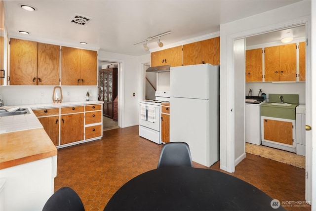 kitchen featuring white appliances, visible vents, brown cabinets, light countertops, and under cabinet range hood