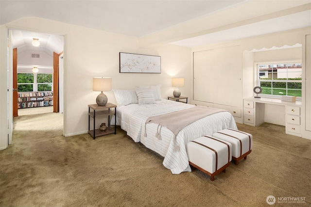 bedroom with carpet floors, visible vents, vaulted ceiling, and built in desk