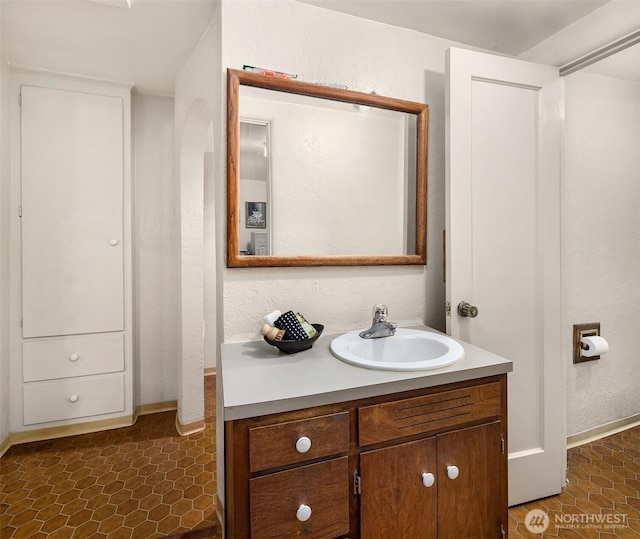 bathroom featuring a textured wall and vanity