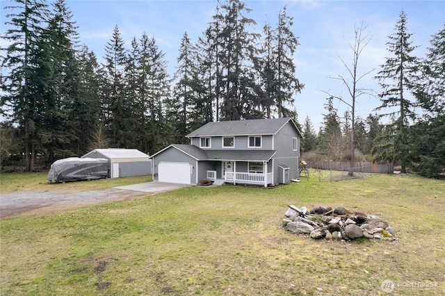 traditional home featuring a porch, a fire pit, a garage, concrete driveway, and a front yard