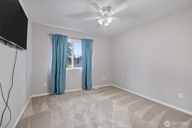 carpeted spare room with ceiling fan, visible vents, and baseboards