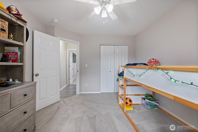 bedroom featuring a ceiling fan, baseboards, a closet, and light colored carpet