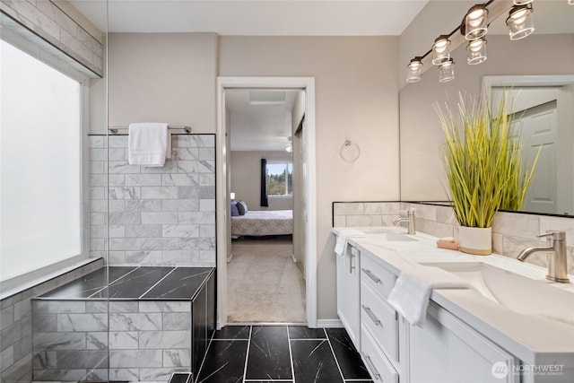 full bath with marble finish floor, double vanity, ensuite bath, and a sink