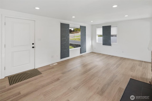 interior space featuring light wood finished floors, baseboards, visible vents, and recessed lighting