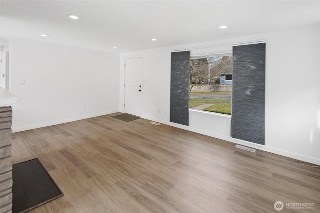 interior space featuring visible vents, baseboards, wood finished floors, and recessed lighting