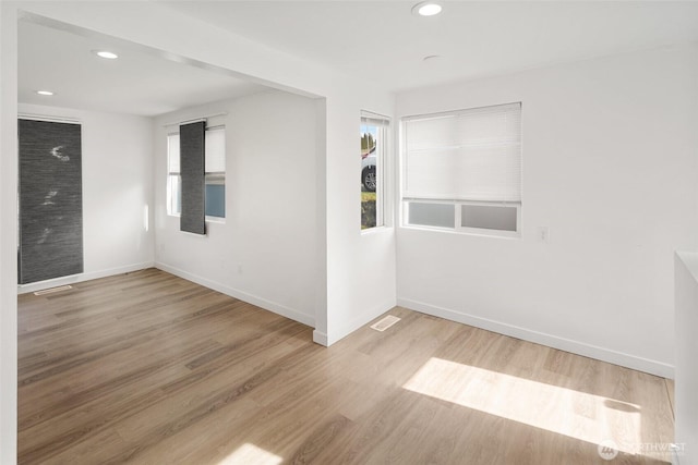 unfurnished room with visible vents, baseboards, wood finished floors, and recessed lighting