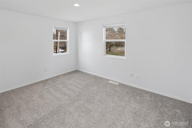 carpeted empty room featuring recessed lighting, visible vents, and baseboards