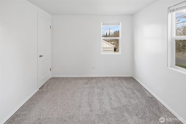 carpeted spare room featuring baseboards