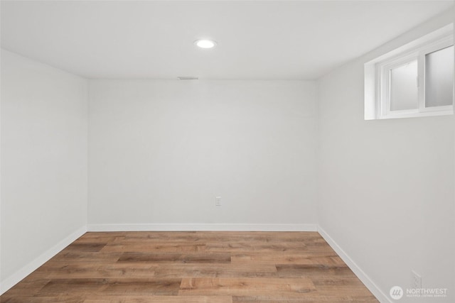 unfurnished room with recessed lighting, wood finished floors, visible vents, and baseboards