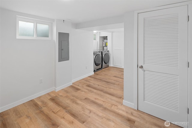 laundry area with laundry area, electric panel, separate washer and dryer, and light wood-style floors