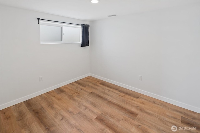 spare room with recessed lighting, visible vents, baseboards, and wood finished floors