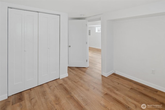 unfurnished bedroom with a closet, baseboards, and wood finished floors