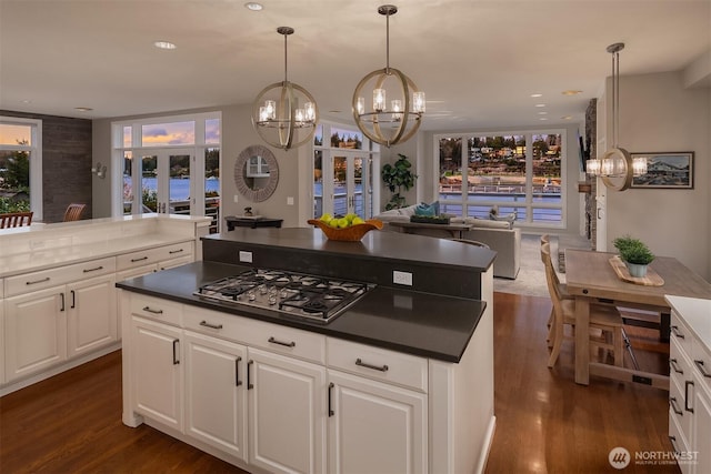 9330 SE Shoreland Dr, Bellevue, WA 98004 - kitchen with stainless steel gas cooktop, white cabinetry, french doors, dark countertops, and decorative light fixtures
