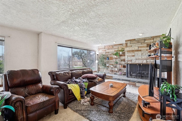 living area with carpet, a stone fireplace, and a textured ceiling