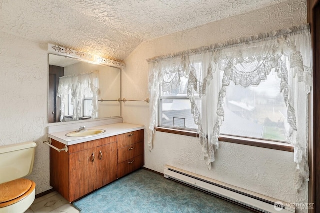 bathroom with a baseboard heating unit, vaulted ceiling, a textured wall, and toilet