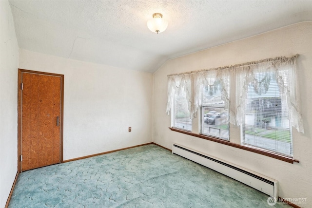 spare room with baseboards, lofted ceiling, a baseboard radiator, carpet, and a textured ceiling