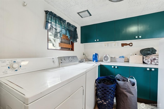 laundry room featuring separate washer and dryer and cabinet space