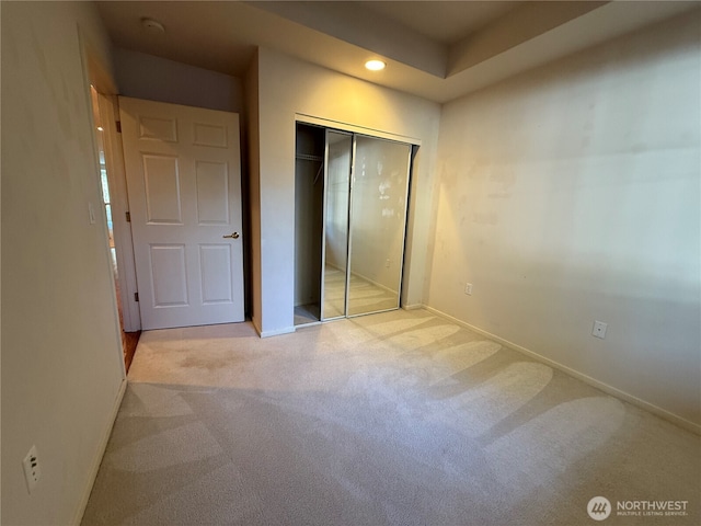 unfurnished bedroom with a closet, baseboards, and carpet flooring