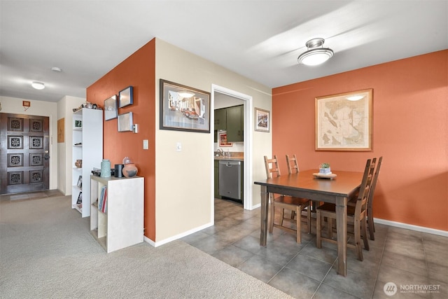 carpeted dining room featuring tile patterned flooring and baseboards