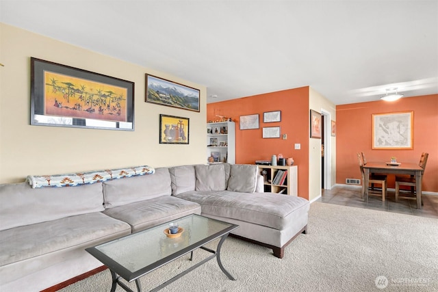 carpeted living area with visible vents and baseboards