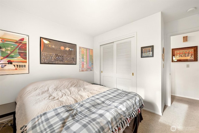 carpeted bedroom with a closet, visible vents, and baseboards