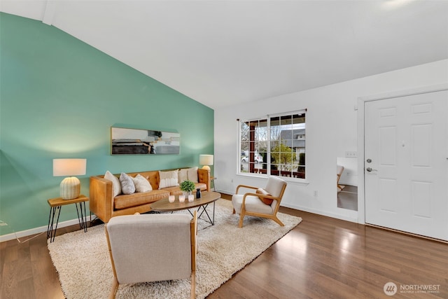 living room featuring lofted ceiling, baseboards, and wood finished floors