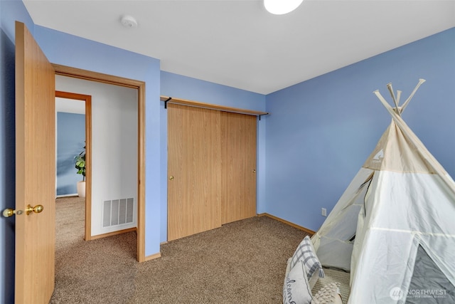 unfurnished bedroom featuring carpet, a closet, visible vents, and baseboards