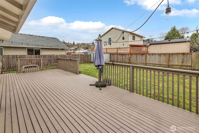 wooden deck featuring a lawn and a fenced backyard