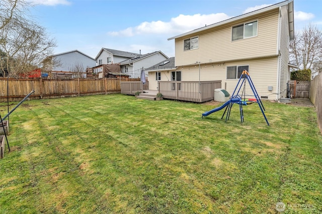 back of property featuring a yard, a fenced backyard, and a wooden deck