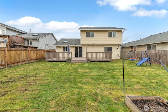 rear view of property with a deck, a playground, a fenced backyard, a garden, and a lawn